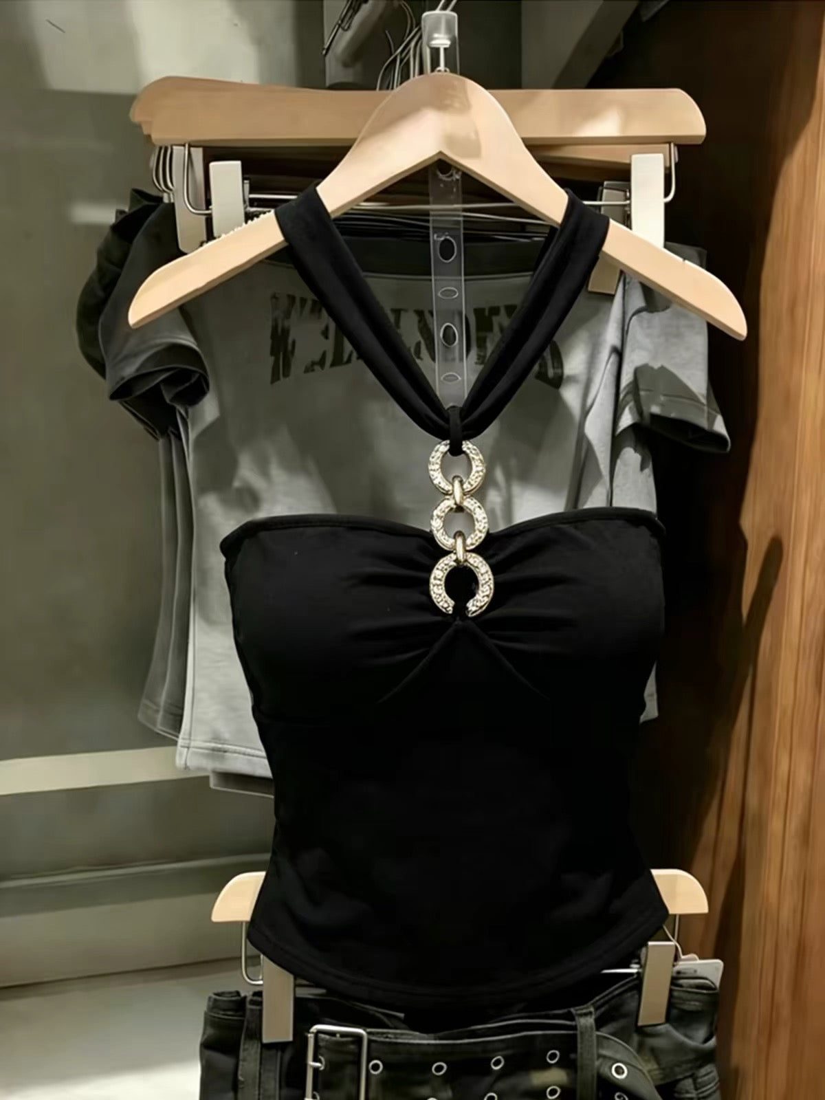 Korean-style black halter-neck tube top featuring cut-out and spliced detailing—a unique, slimming summer piece with a distinctive flair.