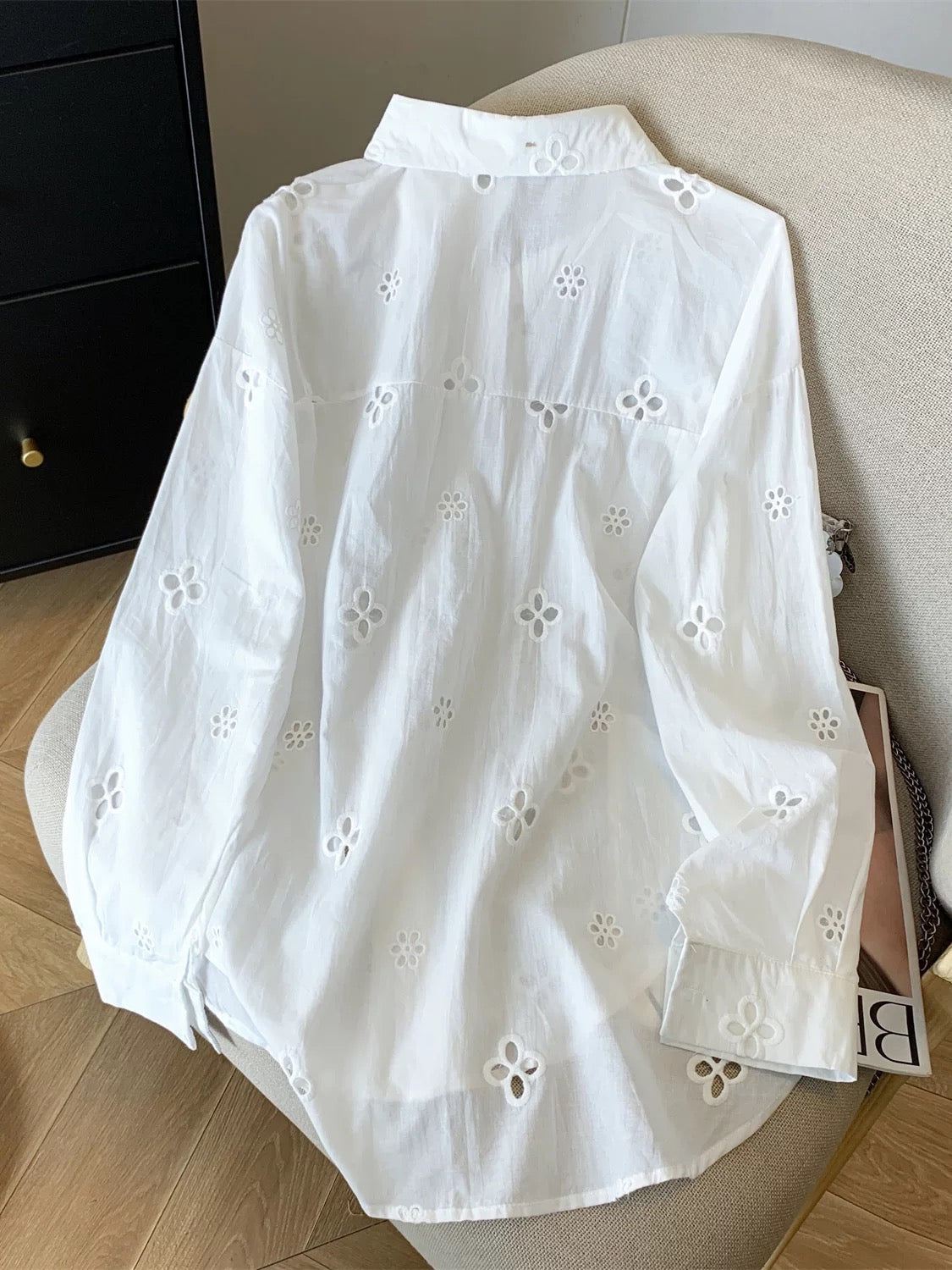 Summer outfit: a complete three-piece casual women's set featuring a hollowed-out embroidered floral sun-protective shirt, suspender top, and shorts.