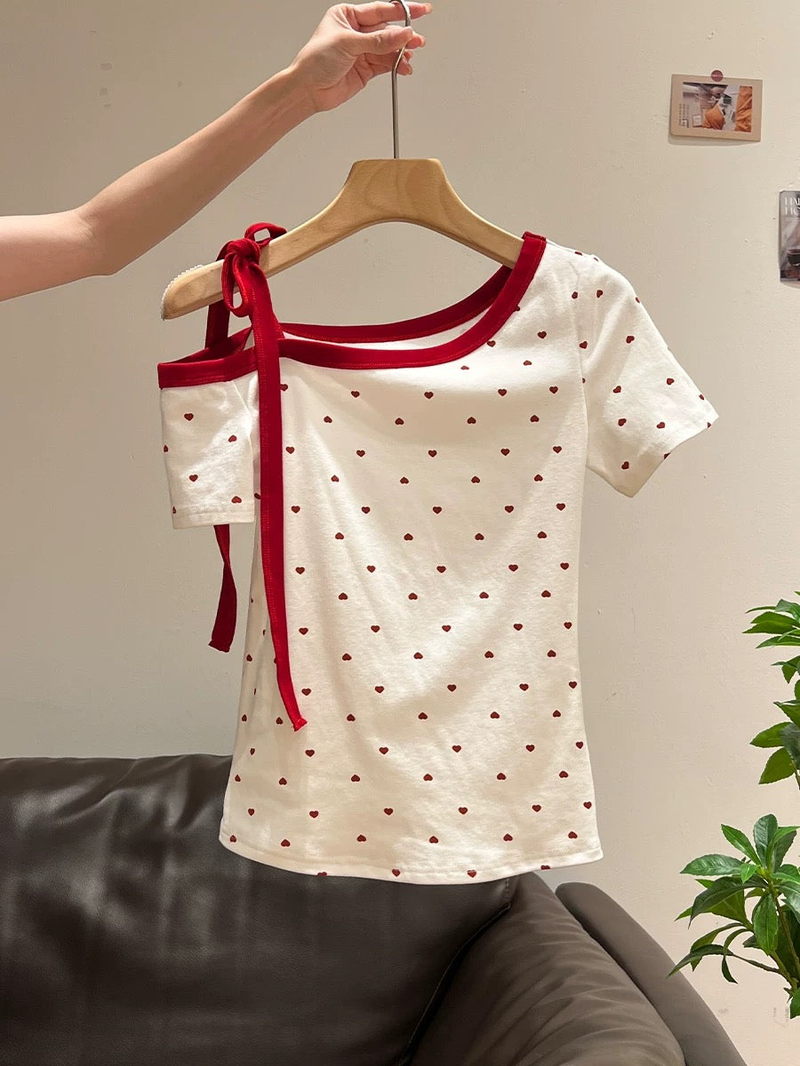Xia Zhen's sexy off-shoulder short-sleeved t-shirt with heart-shaped polka dot print and color-blocked ribbon bow is a feminine and sexy style.