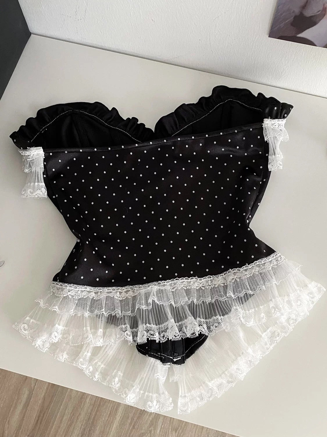 French-style court-inspired top for women, featuring lace trim, sleeveless strapless design, and a fitted boning polka dot pattern.