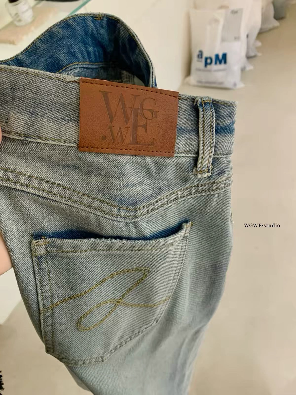 WGWE26 Summer Real-Shot: American-style vintage light-wash denim Bermuda shorts featuring distressed details, whisker fading, and a wide-leg cut.