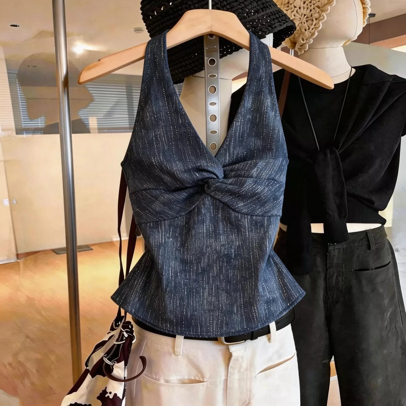 Sexy, sweet, and spicy style: a sleeveless halter-neck top featuring a twisted-front design and a flattering, slim-fit silhouette—a chic, high-fashion take on the denim-look V-neck top.