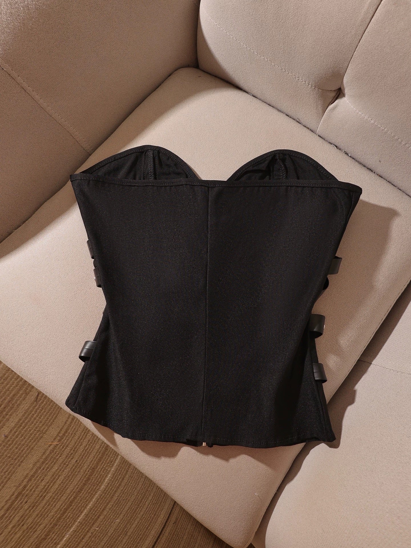 Punk-style black strapless corset top with studs, leather buckle, and lace-up details—a sexy and cool top with a sophisticated, mature vibe.