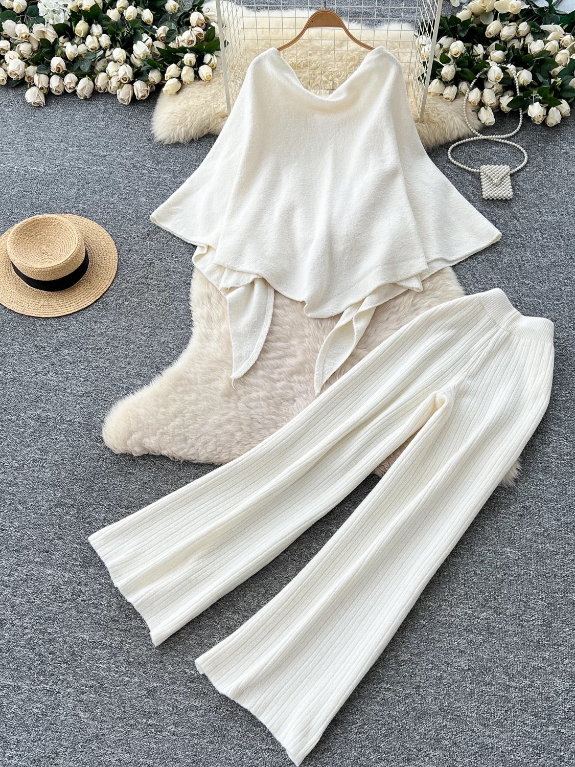 Gentle outfit for women: a three-piece suit with a waist-hugging camisole, a loose sweater, and high-waisted wide-leg pants.