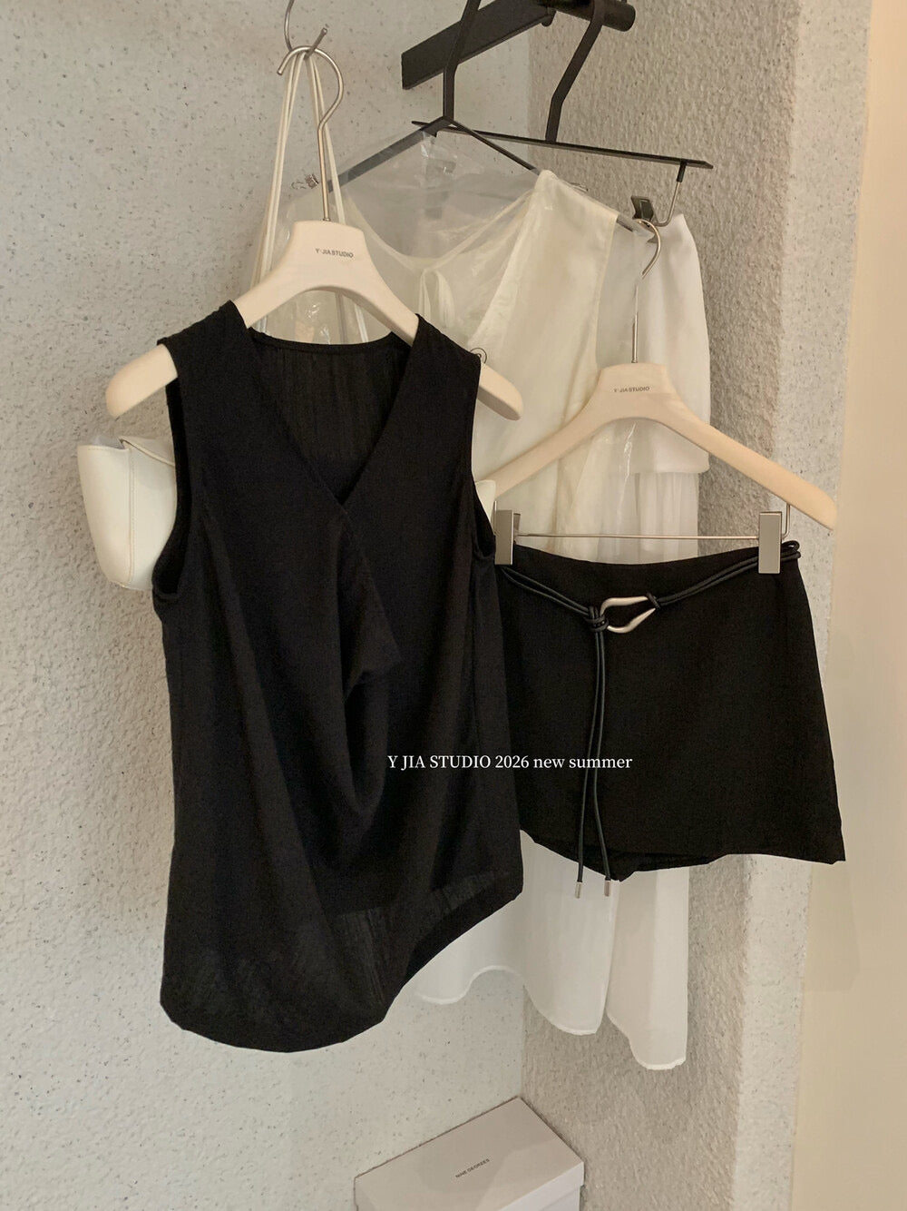 Elegant sleeveless draped-neck top with a high-waisted A-line skirt. Includes a belt and built-in safety shorts for a chic, polished look.