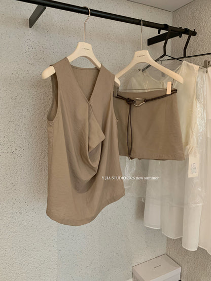 Elegant sleeveless draped-neck top with a high-waisted A-line skirt. Includes a belt and built-in safety shorts for a chic, polished look.