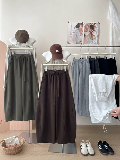Japanese/Korean-style women's wide-leg sweatpants featuring a curved "scimitar" cut and balloon silhouette; designed for autumn/winter with a relaxed, laid-back vibe; versatile and casual, with a drawstring waist and adjustable cinched cuffs.