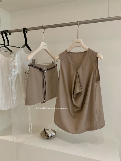 Elegant sleeveless draped-neck top with a high-waisted A-line skirt. Includes a belt and built-in safety shorts for a chic, polished look.