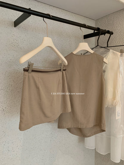 Elegant sleeveless draped-neck top with a high-waisted A-line skirt. Includes a belt and built-in safety shorts for a chic, polished look.
