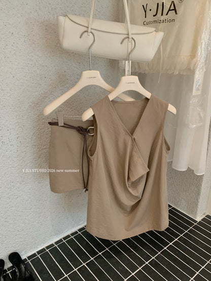 Elegant sleeveless draped-neck top with a high-waisted A-line skirt. Includes a belt and built-in safety shorts for a chic, polished look.