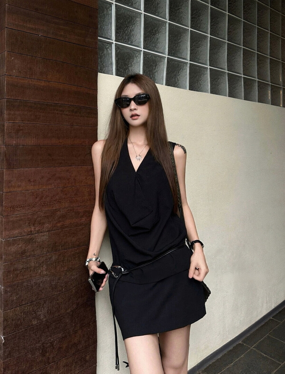 Elegant sleeveless draped-neck top with a high-waisted A-line skirt. Includes a belt and built-in safety shorts for a chic, polished look.