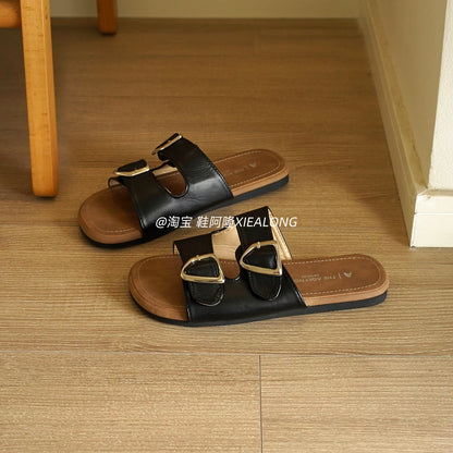 French-style black double-buckle flat slides for women – 2026 summer new arrival featuring metal buckles, suitable for vacation and beach wear.