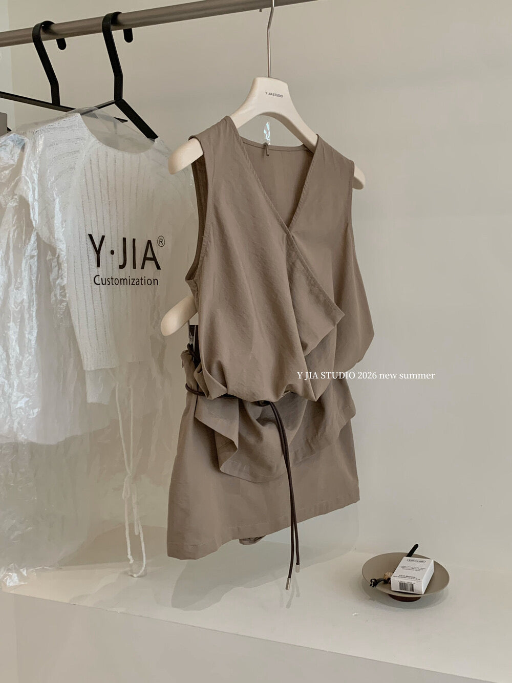 Elegant sleeveless draped-neck top with a high-waisted A-line skirt. Includes a belt and built-in safety shorts for a chic, polished look.