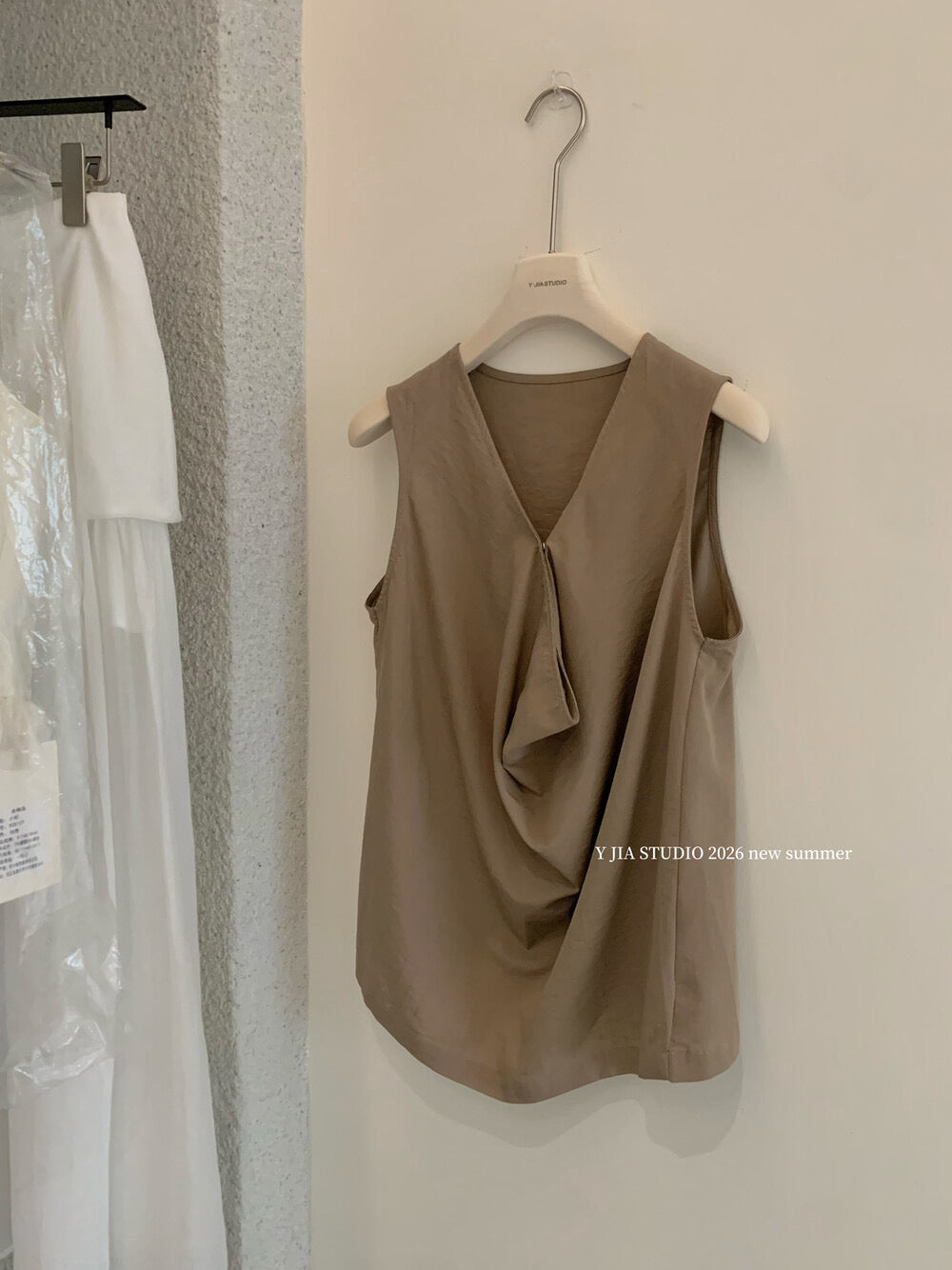 Elegant sleeveless draped-neck top with a high-waisted A-line skirt. Includes a belt and built-in safety shorts for a chic, polished look.