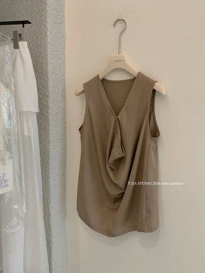 Elegant sleeveless draped-neck top with a high-waisted A-line skirt. Includes a belt and built-in safety shorts for a chic, polished look.
