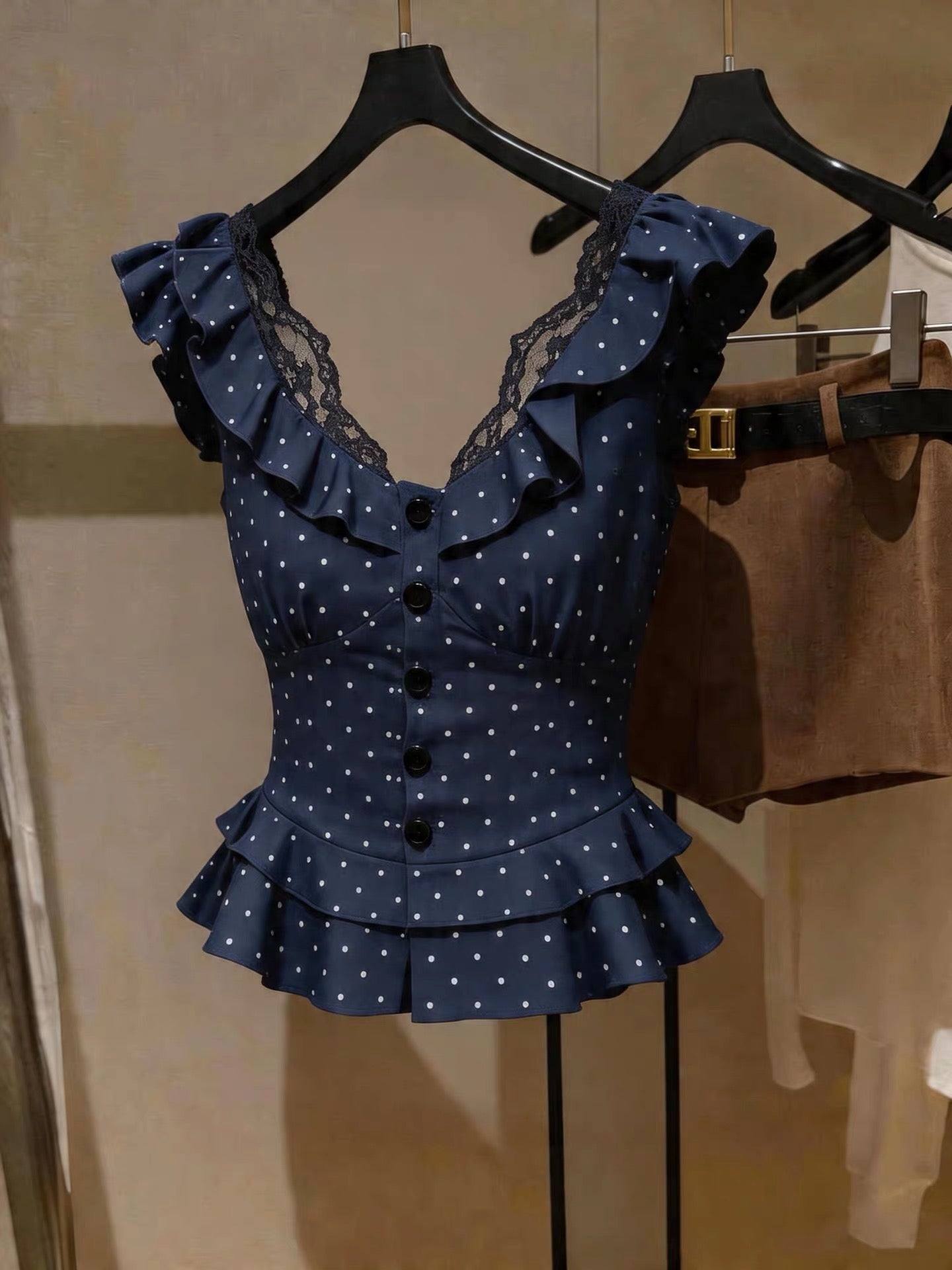 French-style polka-dot V-neck lace-trimmed sleeveless top; a chic, slimming, and stylish blue piece perfect for summer layering.