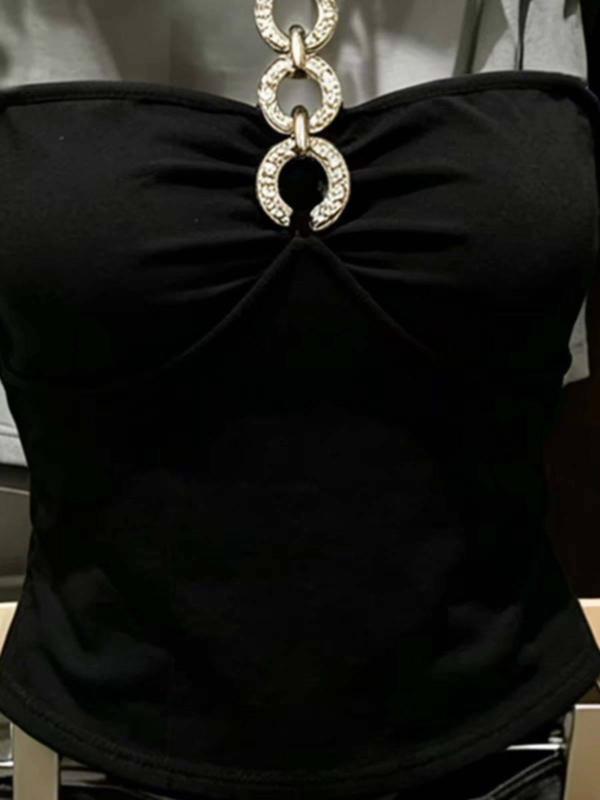 Korean-style black halter-neck tube top featuring cut-out and spliced detailing—a unique, slimming summer piece with a distinctive flair.