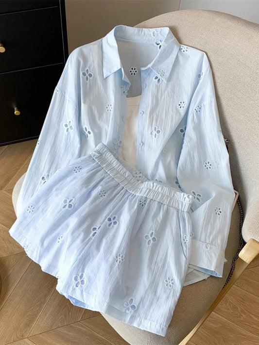 Summer outfit: a complete three-piece casual women's set featuring a hollowed-out embroidered floral sun-protective shirt, suspender top, and shorts.