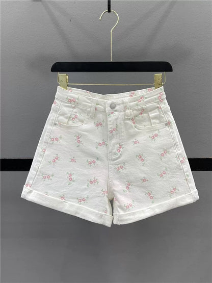 Sweet floral print white denim shorts for women, summer 2026, youthful, high-waisted, slimming, rolled-up A-line wide-leg hot pants.