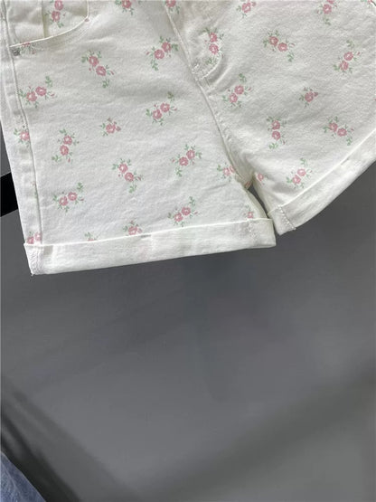 Sweet floral print white denim shorts for women, summer 2026, youthful, high-waisted, slimming, rolled-up A-line wide-leg hot pants.