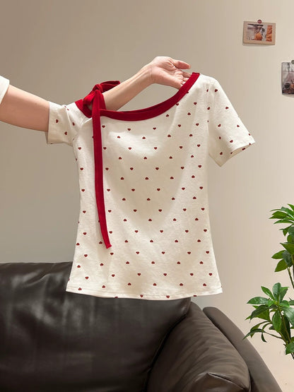 Xia Zhen's sexy off-shoulder short-sleeved t-shirt with heart-shaped polka dot print and color-blocked ribbon bow is a feminine and sexy style.