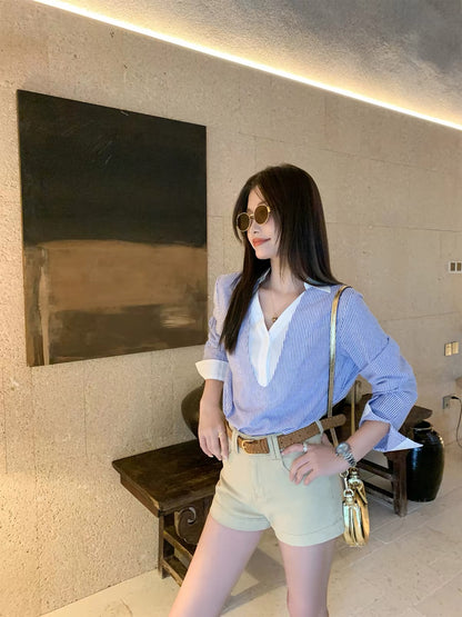 Zeng Xiaoxian Korean-style V-neck blue striped "faux-layered" shirt for women—an early autumn, loose-fit, long-sleeved casual top with a structured shoulder cut.