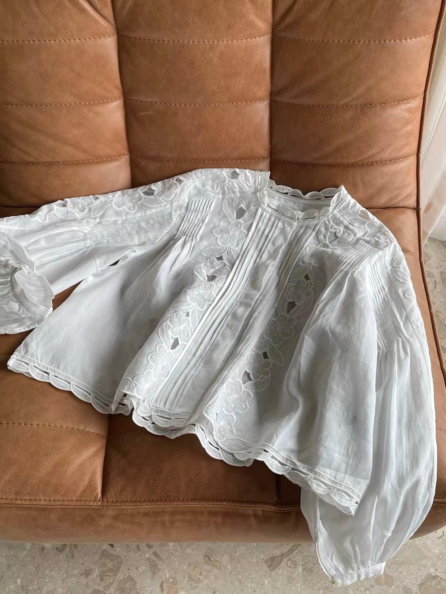 Women's French-style romantic long-sleeve ramie shirt featuring delicate cut-out floral embroidery, vertical pleats, and a lightweight, breathable design—perfect for early autumn.