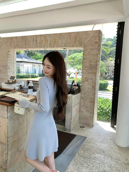 pusumede — A charming, fitted A-line knit mini dress featuring a French-style round neck and long sleeves; designed to flatter the waist and exude an elegant, alluring vibe.