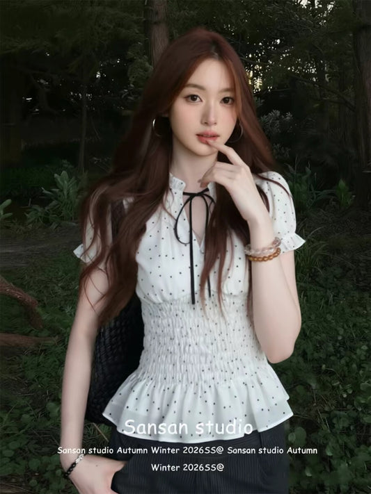French-style white polka-dot short-sleeve blouse for women—perfect for early summer. Features puff sleeves, a waist-cinching fit for a slimming look, and lettuce-edge detailing.