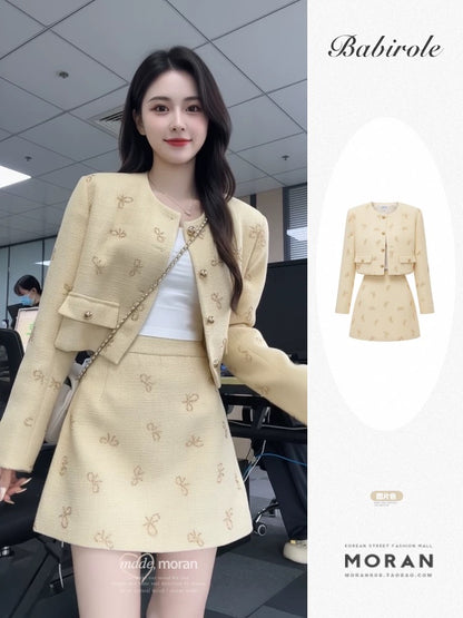 A two-piece set for early autumn, featuring a-inspired bow-tie short jacket and A-line skirt, exuding a sophisticated and elegant style.