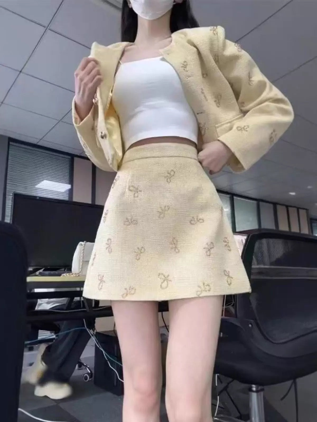 A two-piece set for early autumn, featuring a-inspired bow-tie short jacket and A-line skirt, exuding a sophisticated and elegant style.