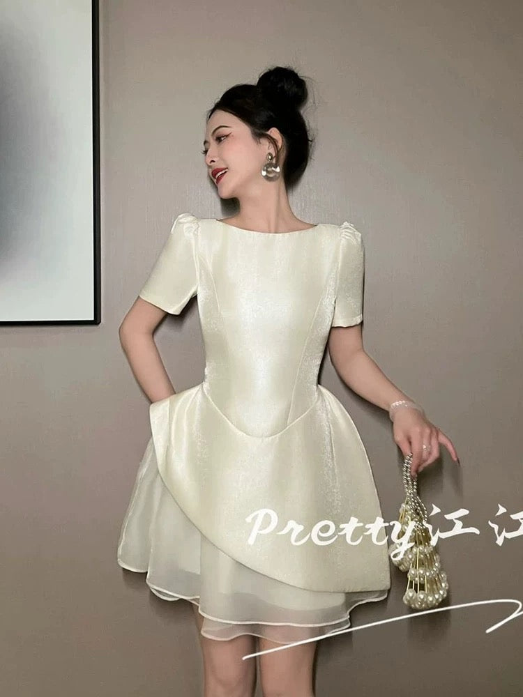 A sophisticated and stylish dress with a high-waisted design that flatters the figure and features a beautiful patchwork mesh tulip skirt.