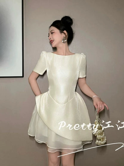 A sophisticated and stylish dress with a high-waisted design that flatters the figure and features a beautiful patchwork mesh tulip skirt.