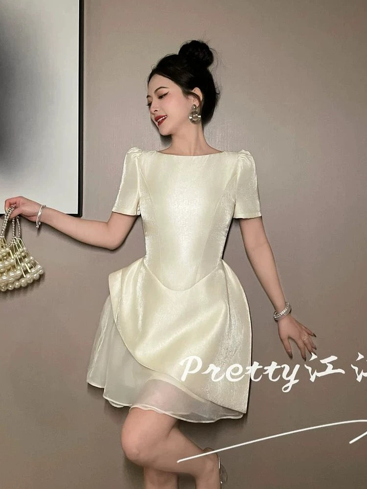 A sophisticated and stylish dress with a high-waisted design that flatters the figure and features a beautiful patchwork mesh tulip skirt.
