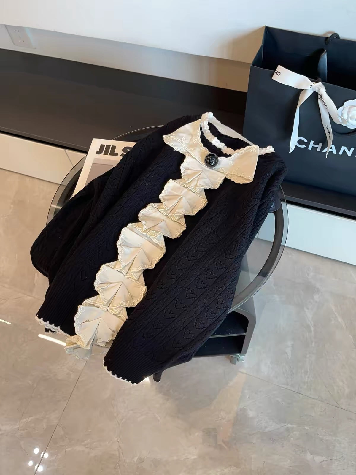 July Launch: Miu-inspired "heiress aesthetic" — black long-sleeve knit cardigan featuring intricate embroidery and a detachable bow.