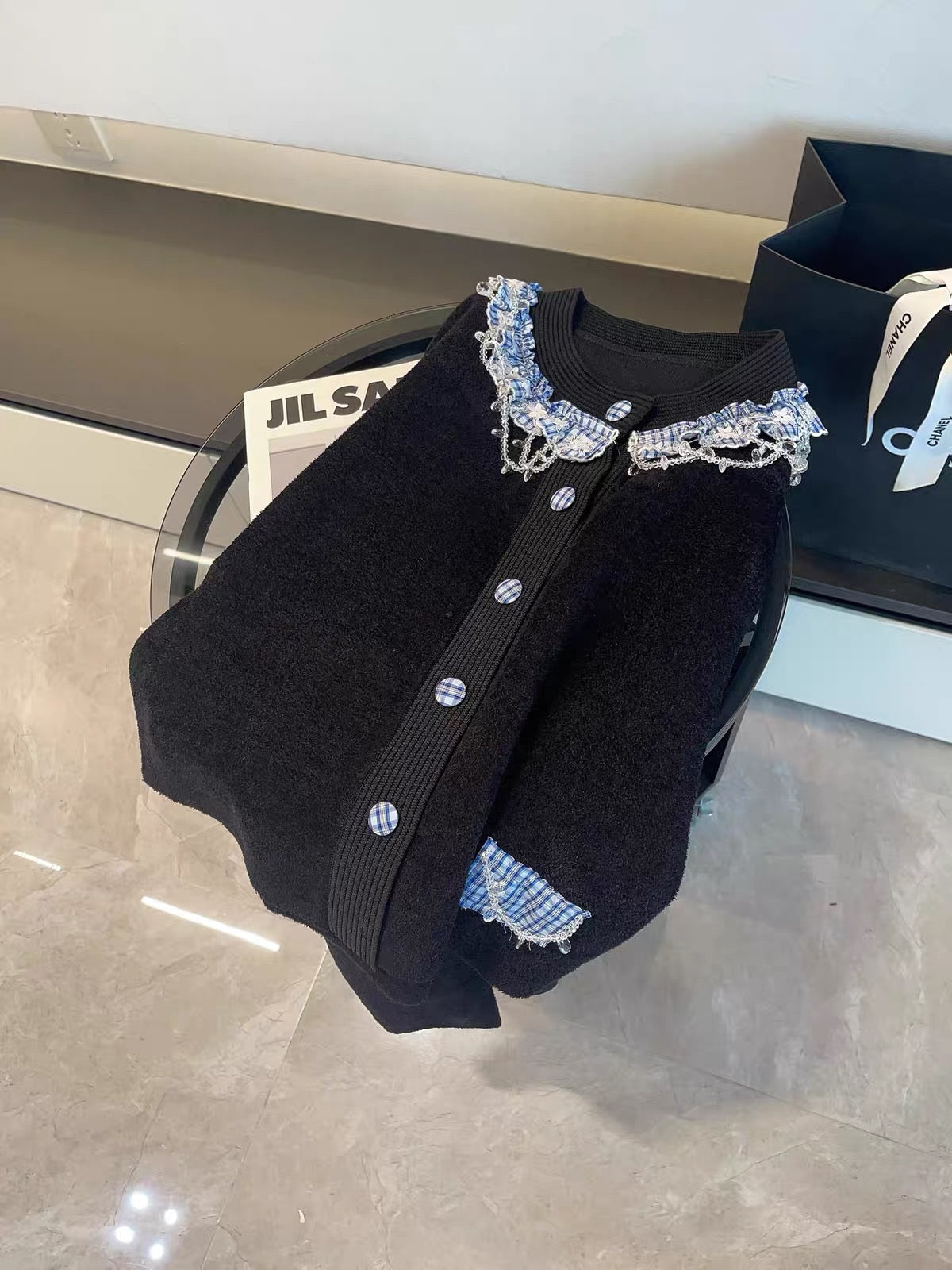 Miu-style luxe aesthetic: Black long-sleeved knit cardigan featuring intricate bead and tassel embellishments.