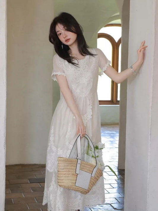 A stunning white lace crochet dress perfect for Spring 2026, exuding a pure, vacation vibe with a unique and beautiful cinched waist.