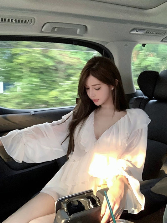 Chill's elegant rosewood runway show featured a deep V-neck ruffled chiffon blouse in a soft white, slightly sheer design.