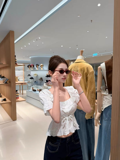 CHICYOU "m1u Pure Style" White Short-Sleeve Blouse with Cut-Out Embroidery, Ruffled Collar, and Waist Belt