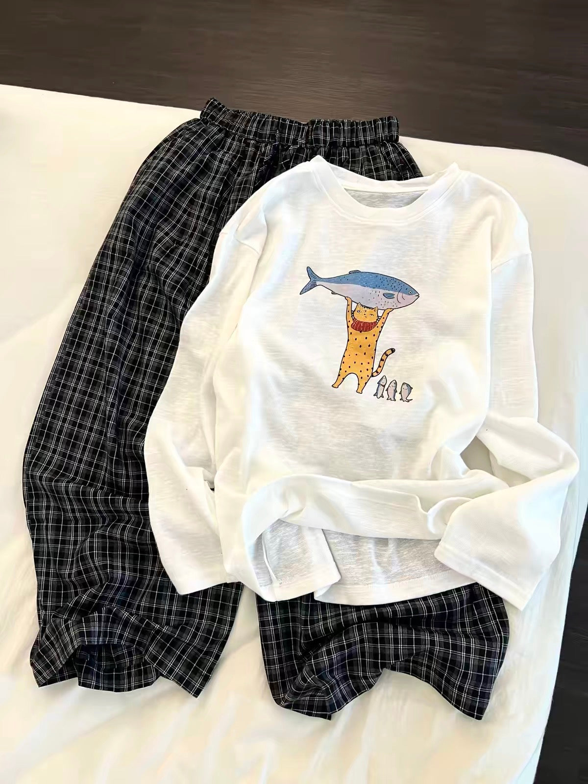 Korean-style casual long-sleeved pajama set for women—featuring a cartoon print top and loose plaid trousers; suitable for loungewear or casual wear; available in plus sizes.