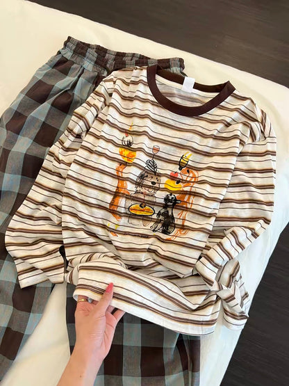 Women's Korean-style loungewear set featuring a striped long-sleeve top with a cartoon print and plaid trousers; a relaxed, laid-back autumn style suitable for wearing both at home and outdoors.