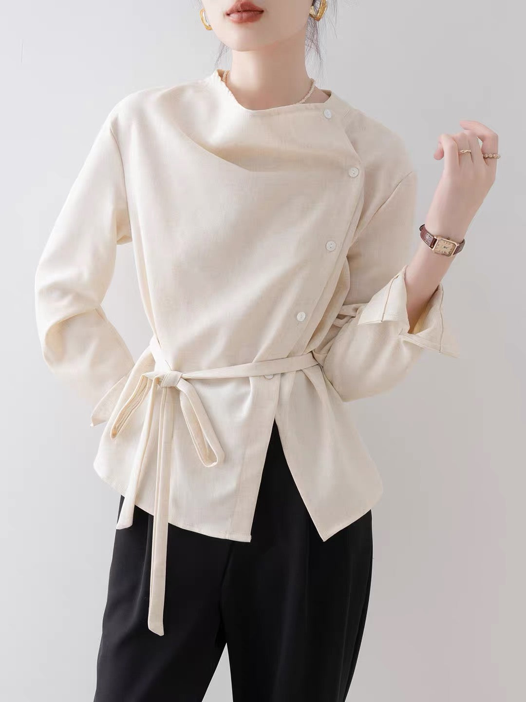 Women's French-style vintage asymmetrical blouse (New for Autumn 2026): an elegant, off-white, waist-cinching shirt featuring a draped neckline.