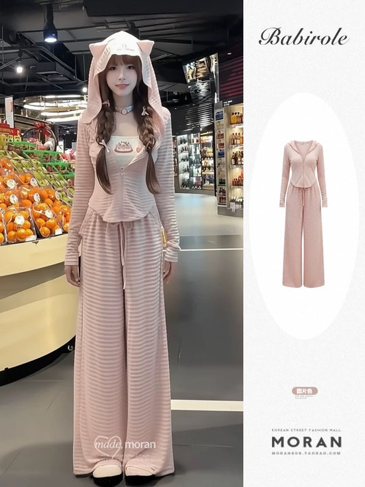 A sweet and spicy two-piece set in pink, featuring a fitted sweatshirt, cardigan, and wide-leg pants, perfect for early autumn and a sporty look.