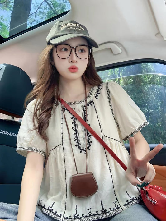 Apricot-colored short-sleeved shirt with square shoulders and flutter sleeves, a new summer style for 2026, featuring a unique design from a niche trendy brand.