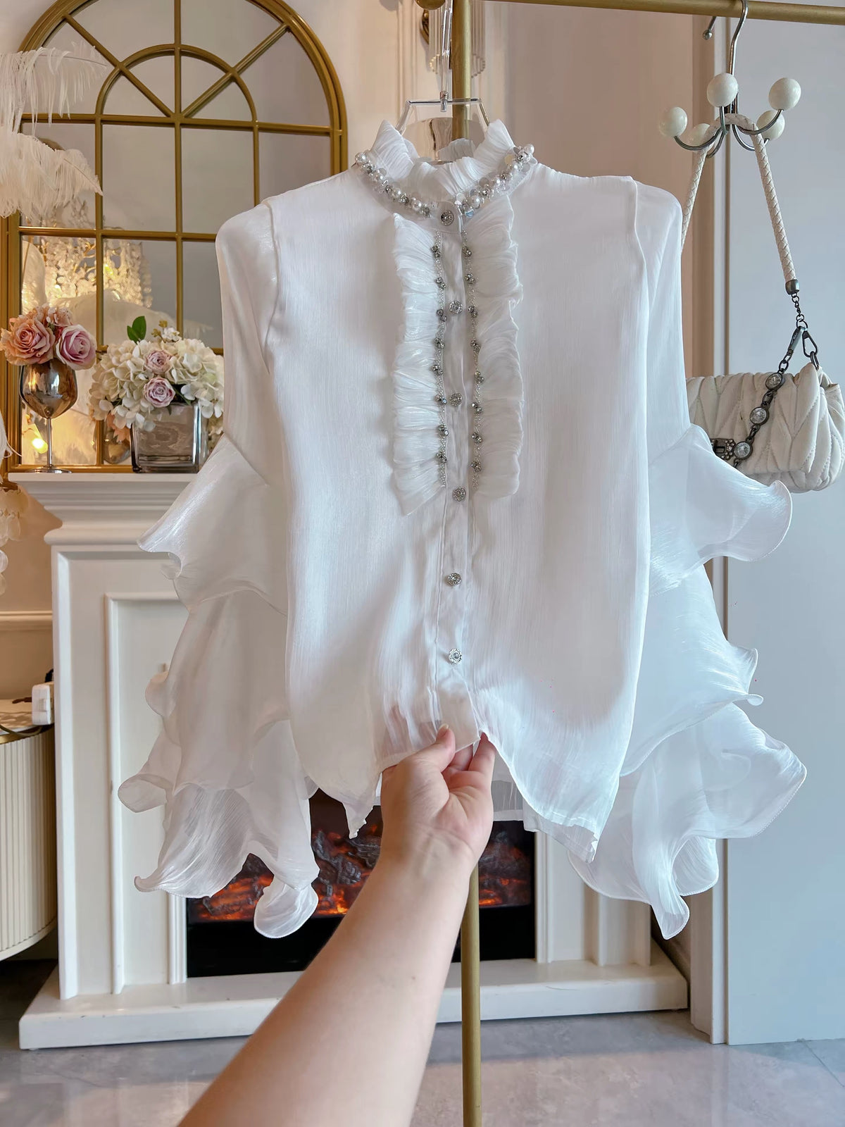 Women's Loose-Fit White Chiffon Shirt (Fall/Winter 2026): Features Elaborate Rhinestone Embellishments, Ruffled Details, Single-Breasted Closure, and Flared Sleeves.