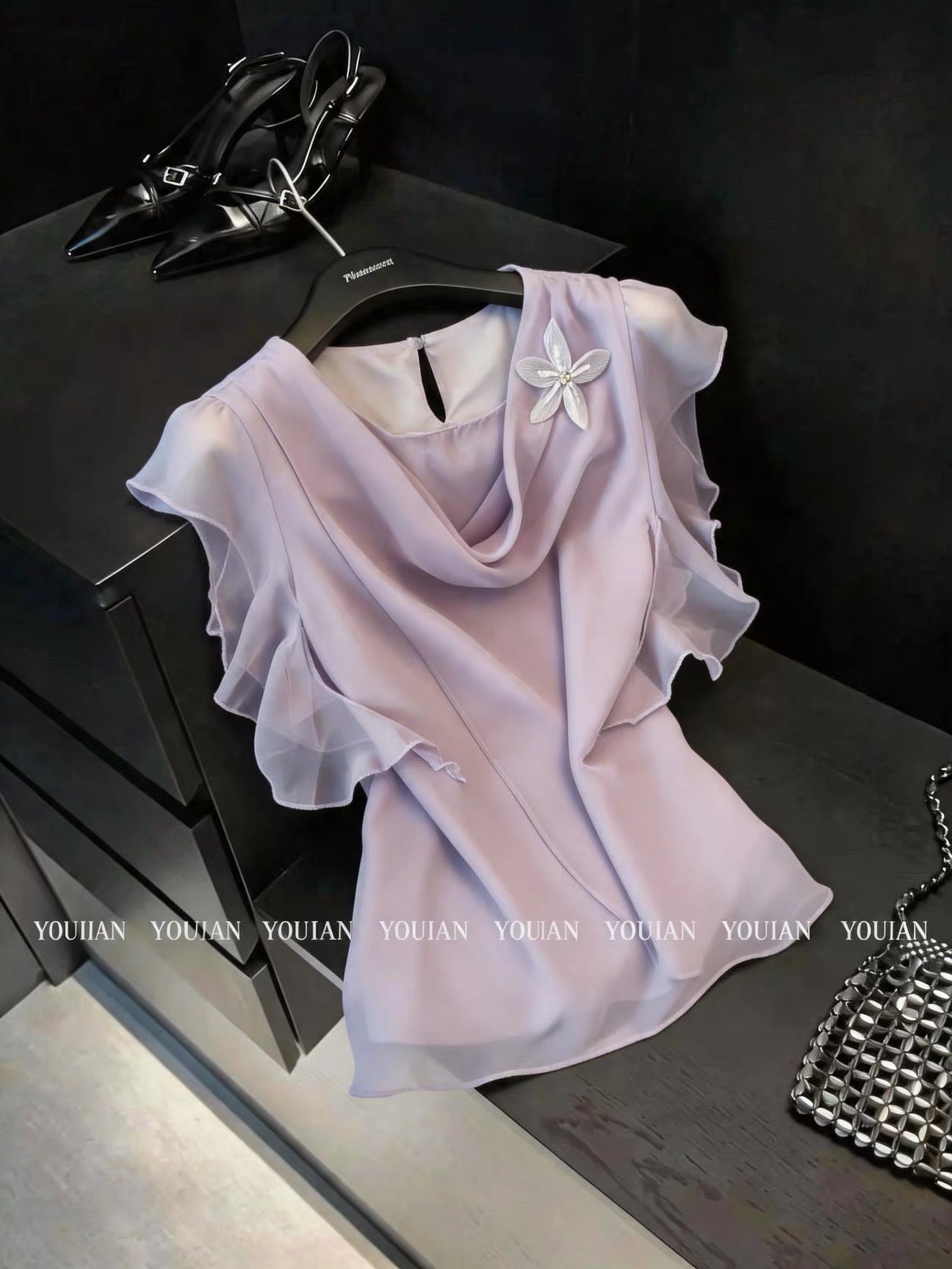 French chic and sophisticated design: a chiffon blouse with a flowing neckline, three-dimensional floral ruffles, and short sleeves.