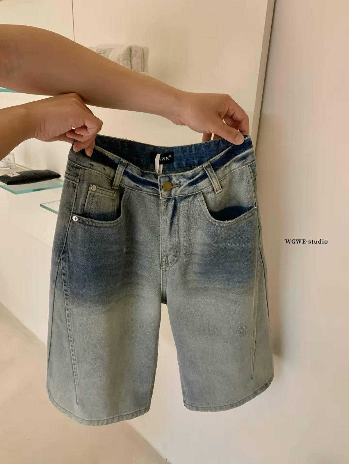 WGWE26 Summer Real-Shot: American-style vintage light-wash denim Bermuda shorts featuring distressed details, whisker fading, and a wide-leg cut.
