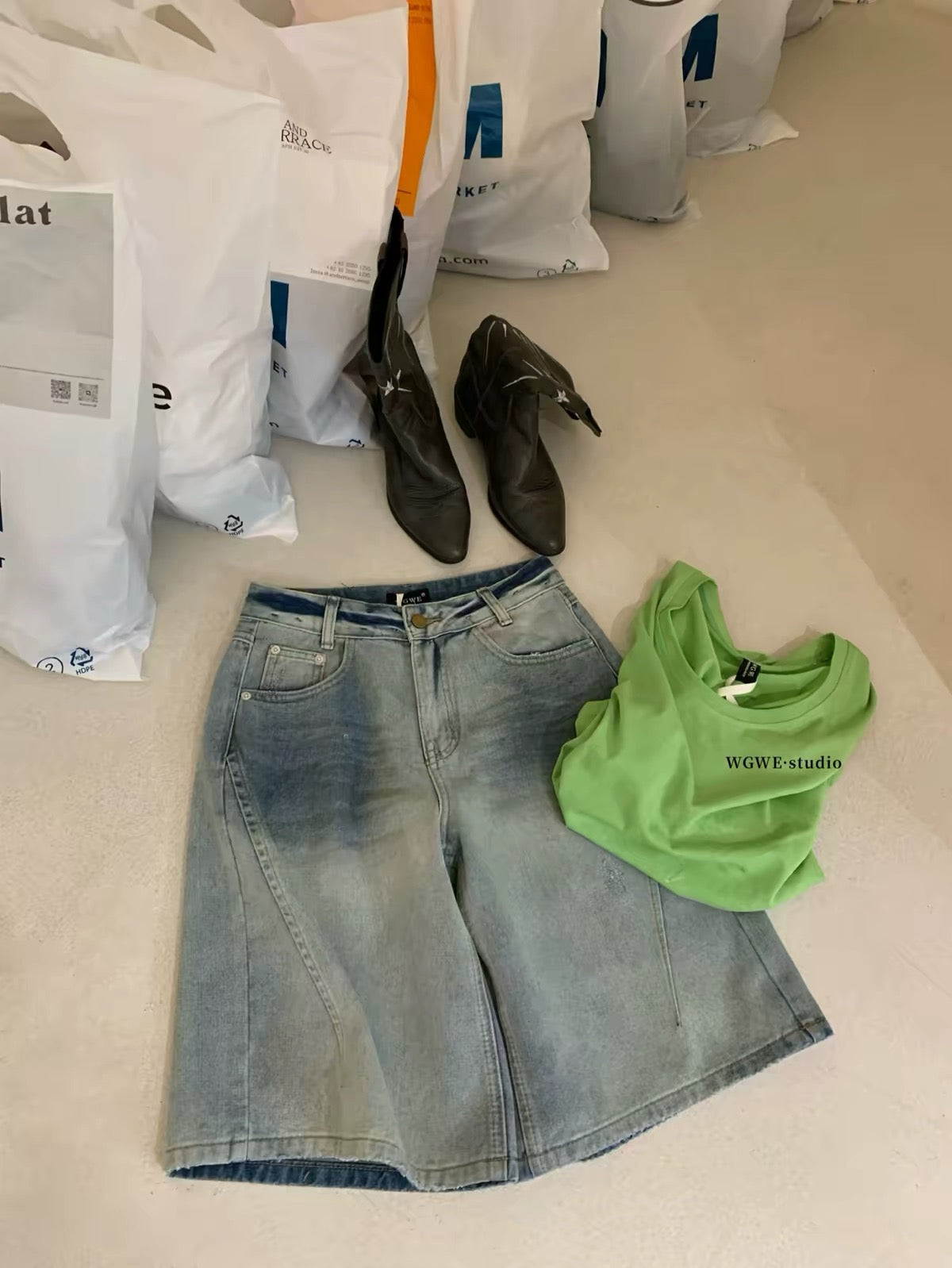 WGWE26 Summer Real-Shot: American-style vintage light-wash denim Bermuda shorts featuring distressed details, whisker fading, and a wide-leg cut.
