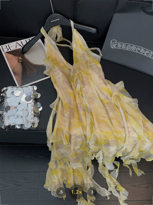 Yellow tie-dye halter-neck dress with irregular ruffles and ribbon design, featuring a sweet and spicy backless style.
