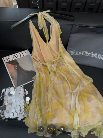Yellow tie-dye halter-neck dress with irregular ruffles and ribbon design, featuring a sweet and spicy backless style.
